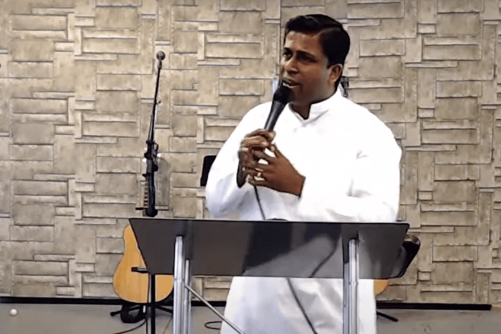 A man speaking into a microphone at a church.